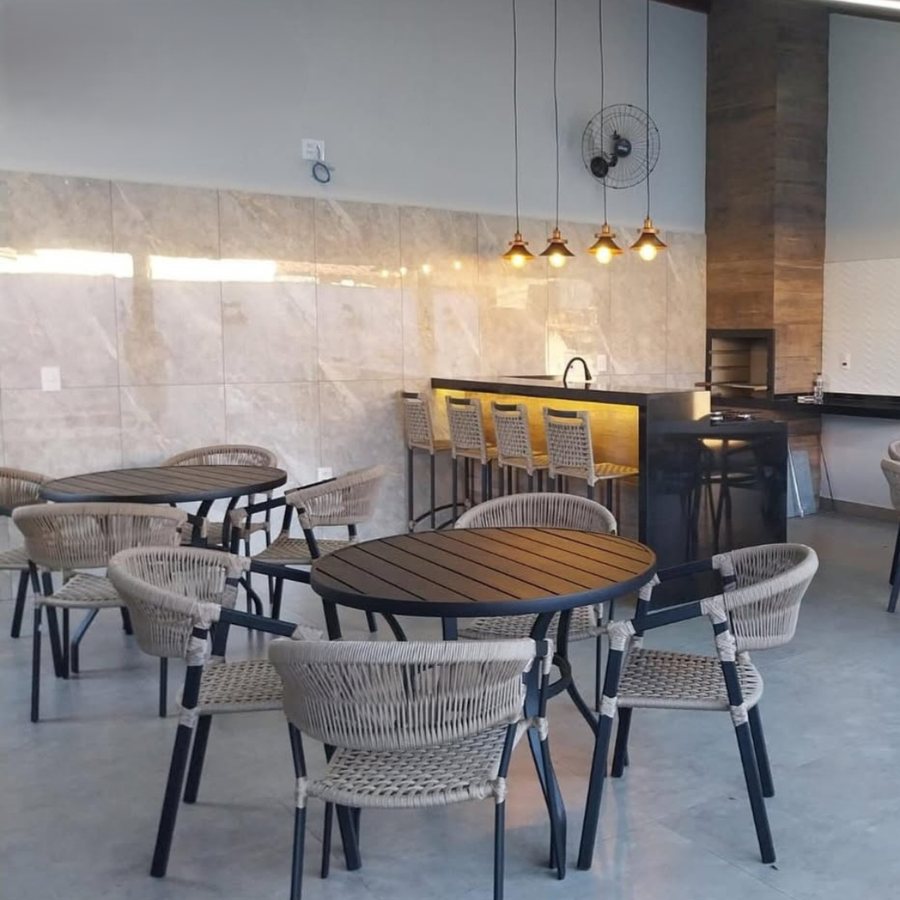 Área de lazer com mesa, cadeiras e banquetas gourmet