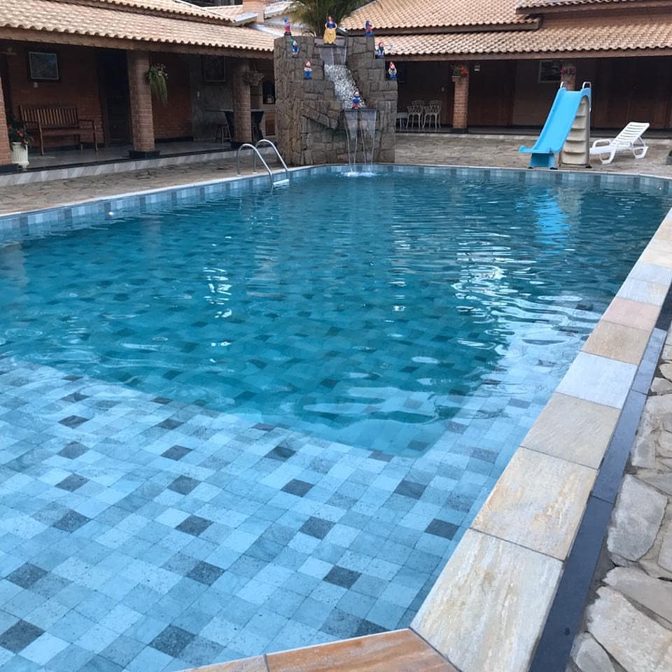 Piscina de alvenaria com cascata, escorregador e área de estar